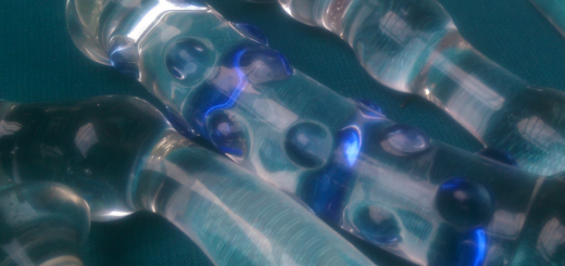 Is your glass sex toy safe? Image shows an array of glass sex toys on a teal background