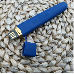 Navy blue Crave Flex showing with the attached silicone cap off to see the charging plug