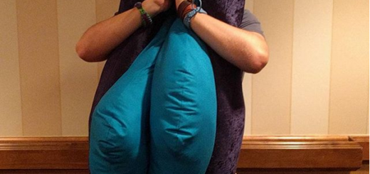 This is a photo of Kenton wearing a giant plushie vulva, and his head is where the clitoris would be. He's emulating Zach of Buzzfeed who wore a similar costume in a Buzzfeed video and adorably realized his head was the clitoris and was very excited.