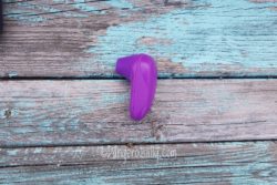 Womanizer Starlet in purple against a wood background