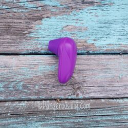 Womanizer Starlet in purple against a wood background